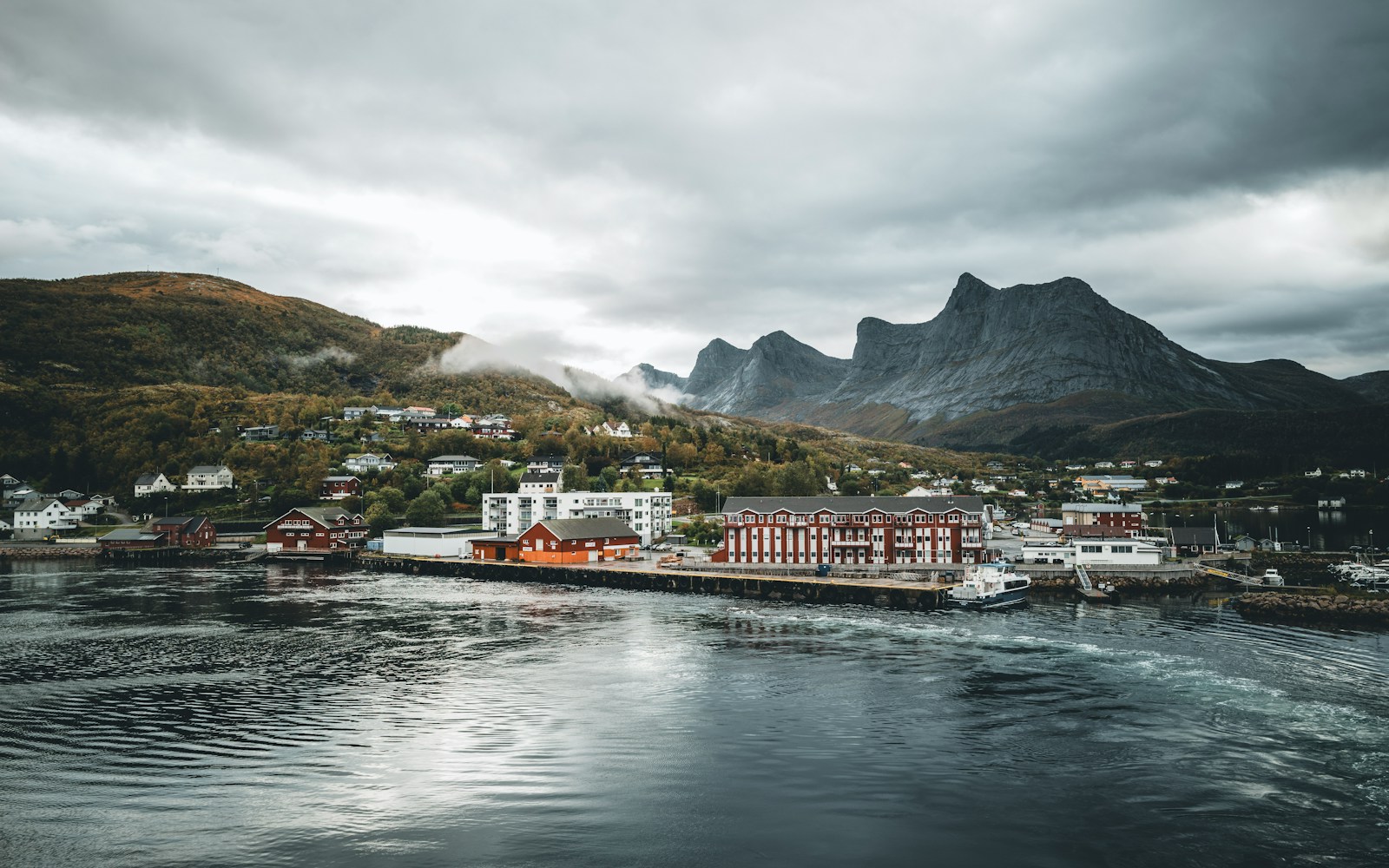 A picturesque coastal town nestled against mountains.